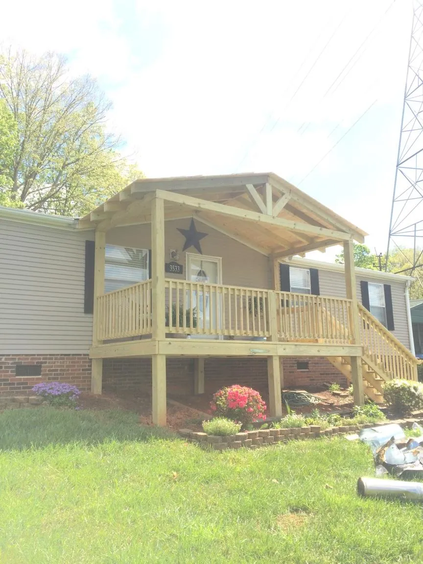 New gabled porch roof and deck railing added to a ranch home in Derry